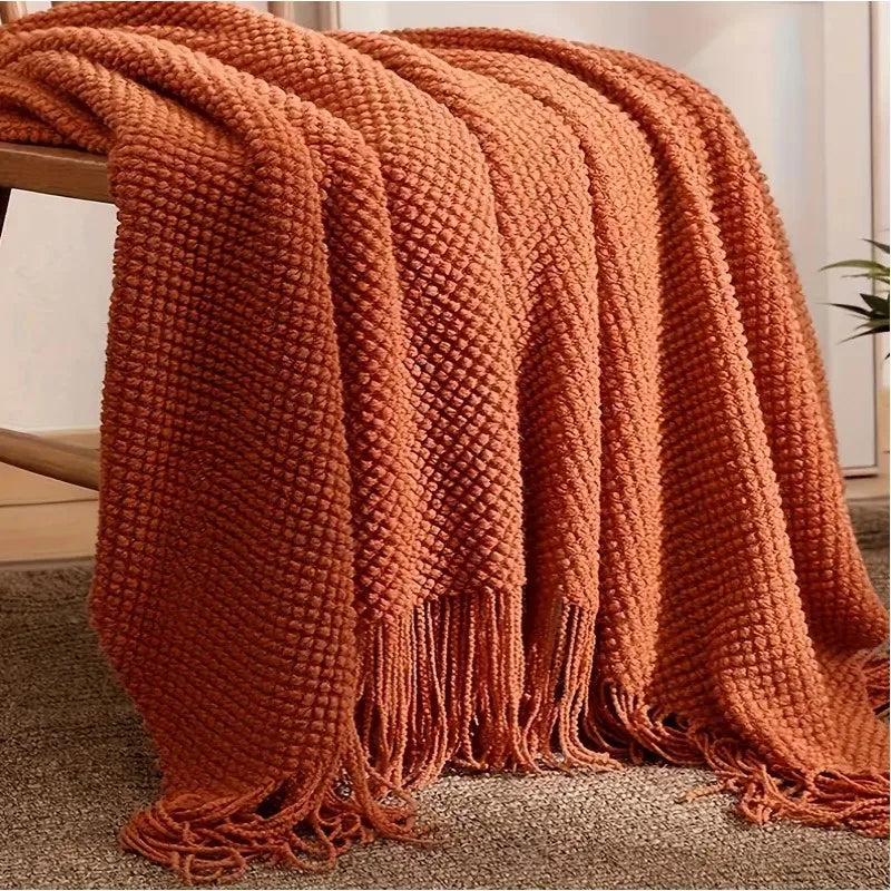 Plaid cocooning en maille sur un canapé