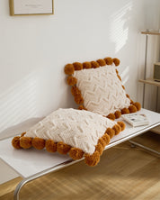 Coussin avec pompons en matière moumoute