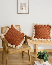 Oreiller avec pompons en matière peluche