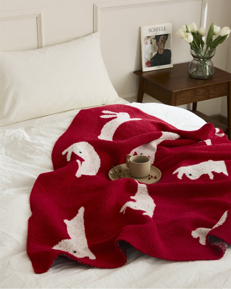Plaid rouge en matière polaire avec des motifs d'animaux